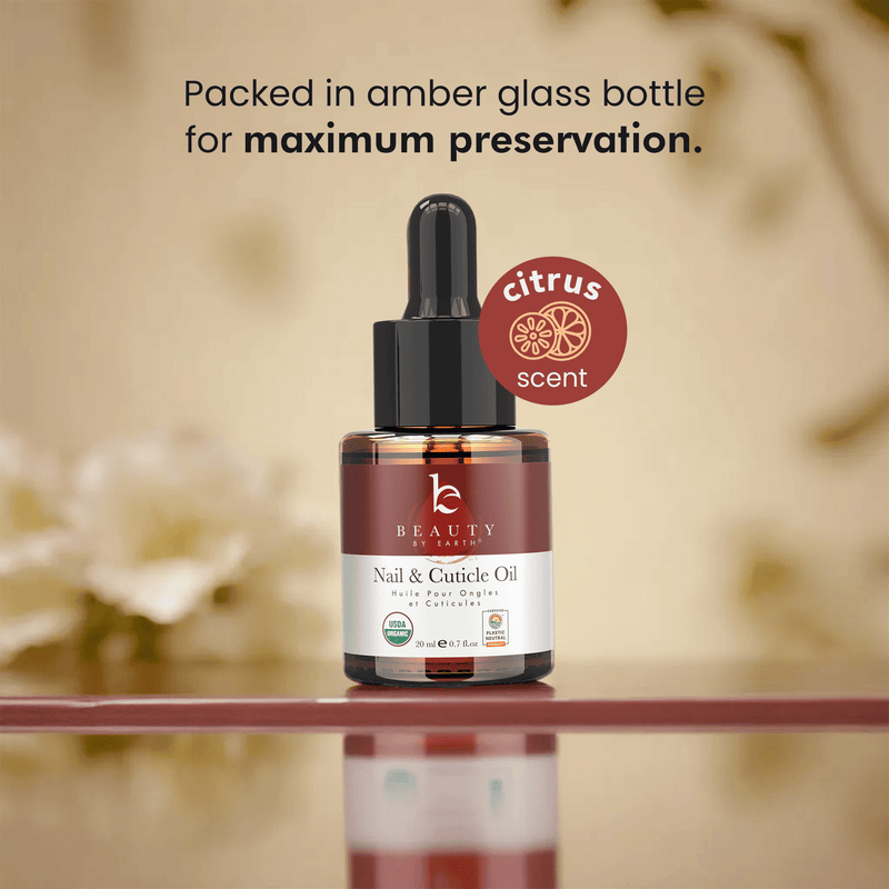 Nail and cuticle oil bottle with dropper labeled 'citrus scent' on a reflective surface.