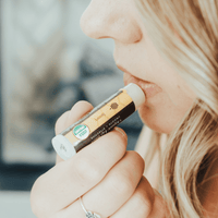 Person using a vape pen with a blurred background