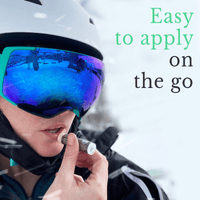 Person wearing ski goggles and helmet with text 'Easy to apply on the go' in a snowy outdoor setting.