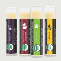 Four organic lip balm tubes with different flavors on a white background