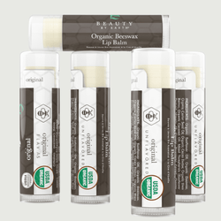 Set of organic beeswax lip balms with visible branding on a light gray background