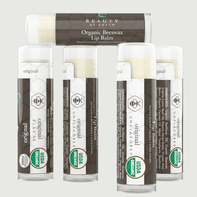Set of organic beeswax lip balms with visible branding on a light gray background