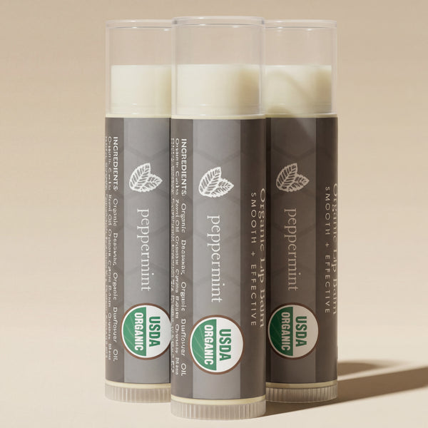 Three tubes of peppermint lip balm with USDA Organic labels on a light gray background