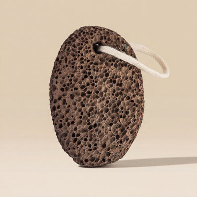 Brown pumice stone with a white string on a beige background