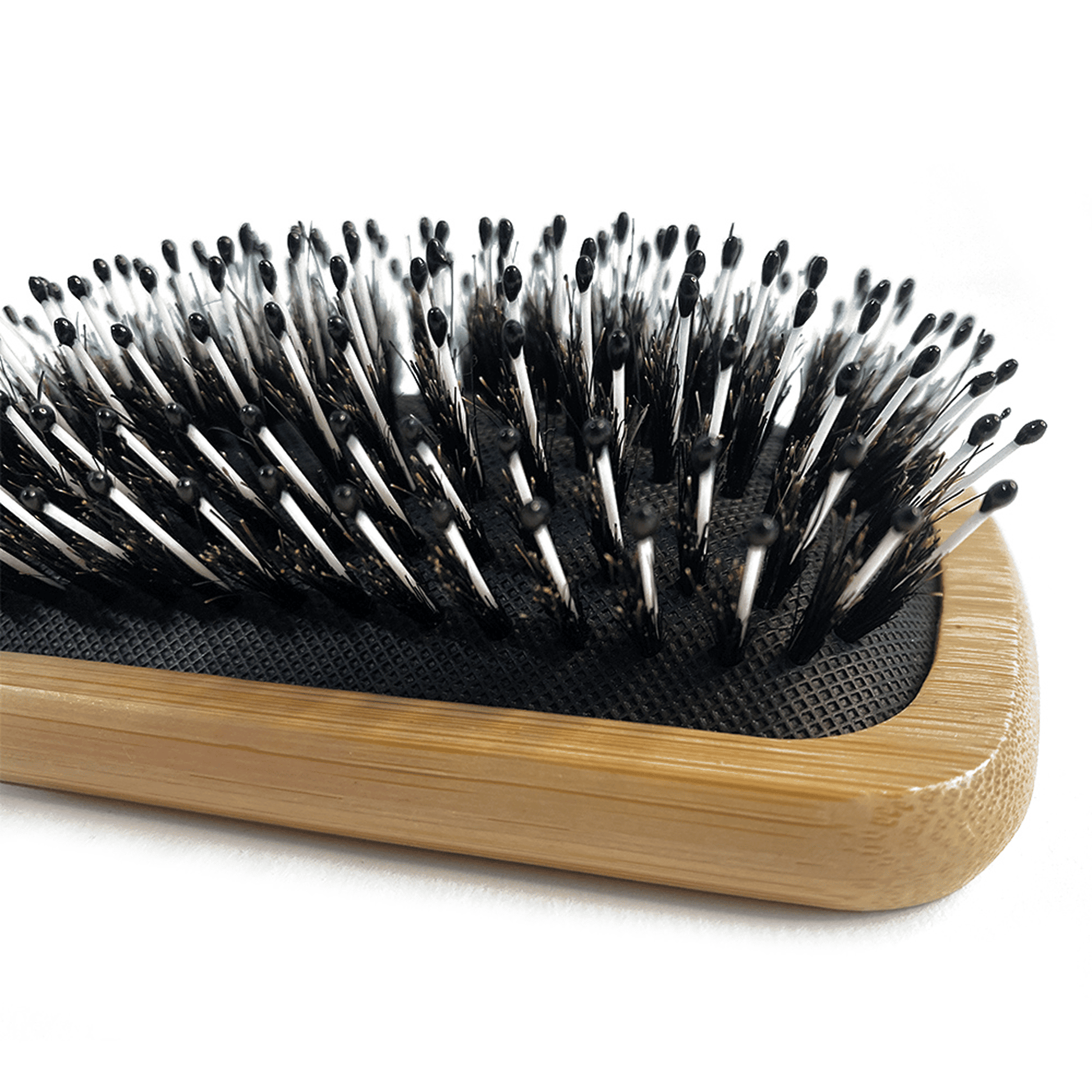 Hairbrush with black bristles and wooden handle on a white background