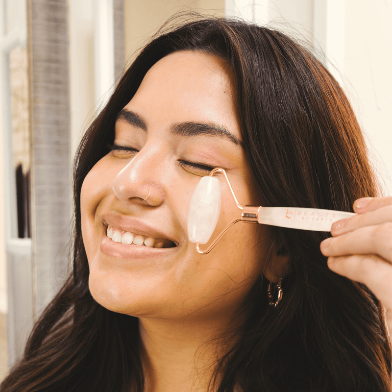 Woman using a face roller on her face with a blurred background