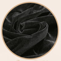 Close-up of black velvet fabric with a beige circular border