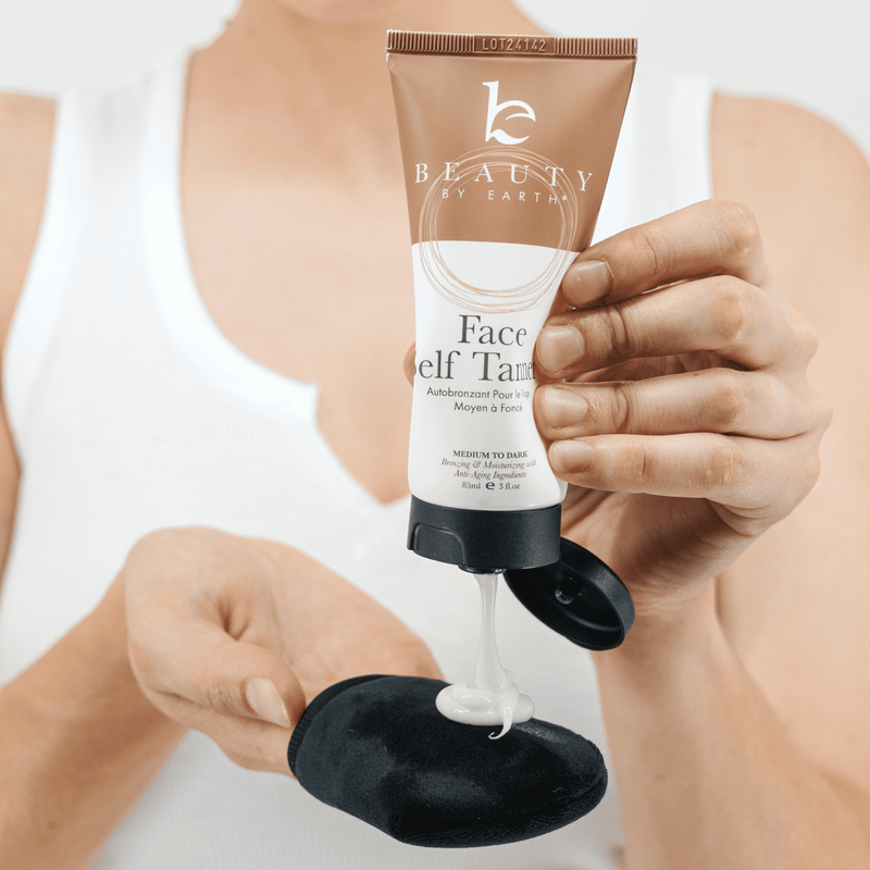 A model squeezing face self tanning lotion on a black face mitt