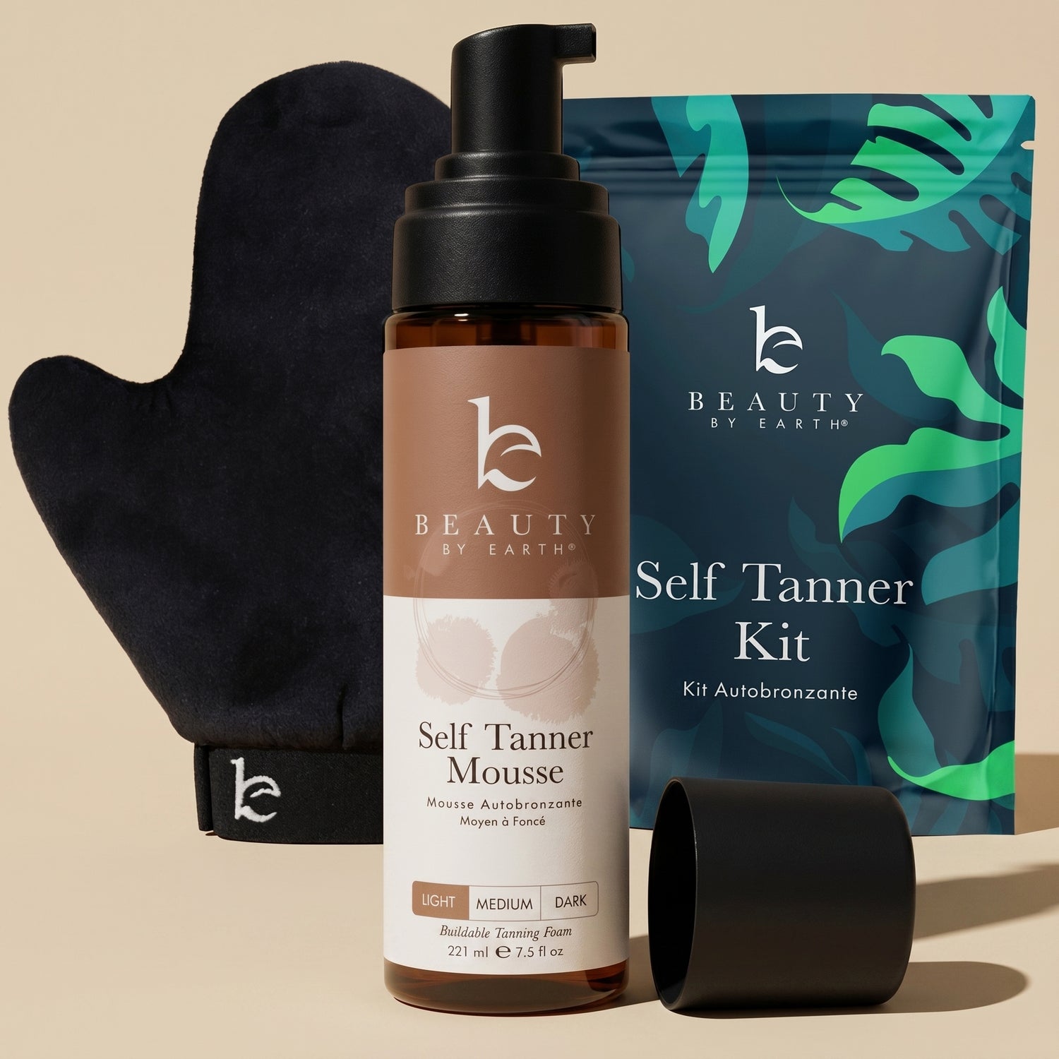 Beauty by Earth self Tanner mousse, mitt, and packaging on a beige background