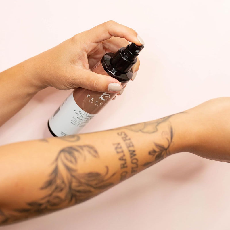 A woman applying Self Tanning Body Tanner Spray on her arm