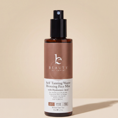 Beauty by Earth self-tanning water bronzing face mist bottle on a beige background