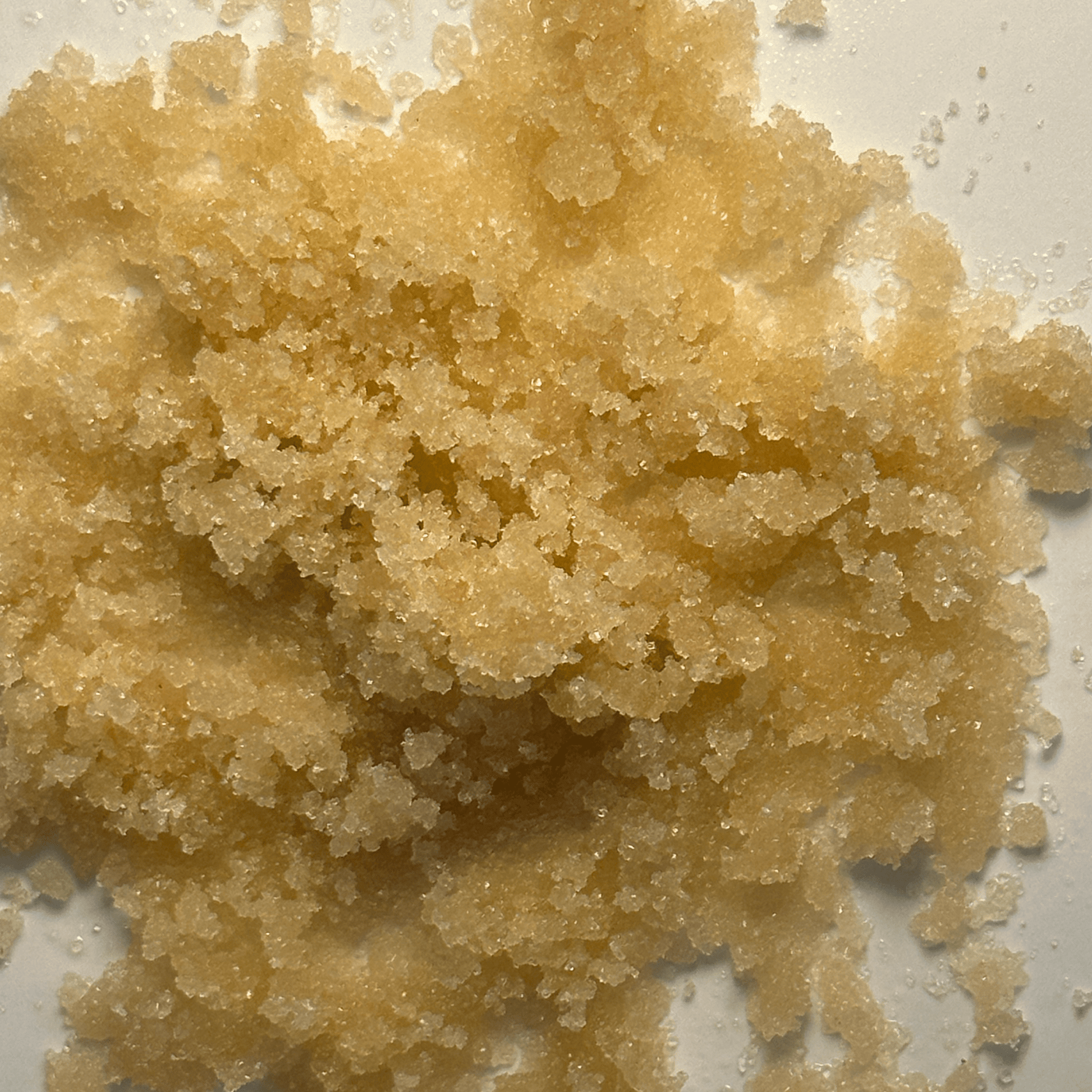 Close-up of a pile of brown sugar crystals on a white background