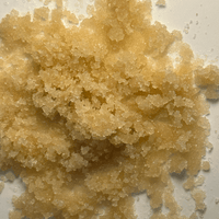 Close-up of a pile of brown sugar crystals on a white background