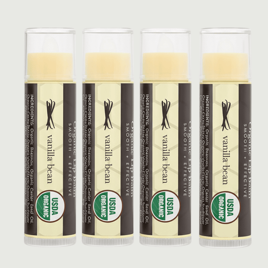 Four Vanilla Bean Organic lip balms on a light gray background