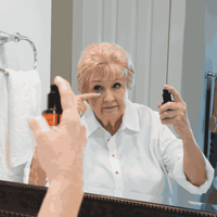 Woman applying makeup in front of a mirror