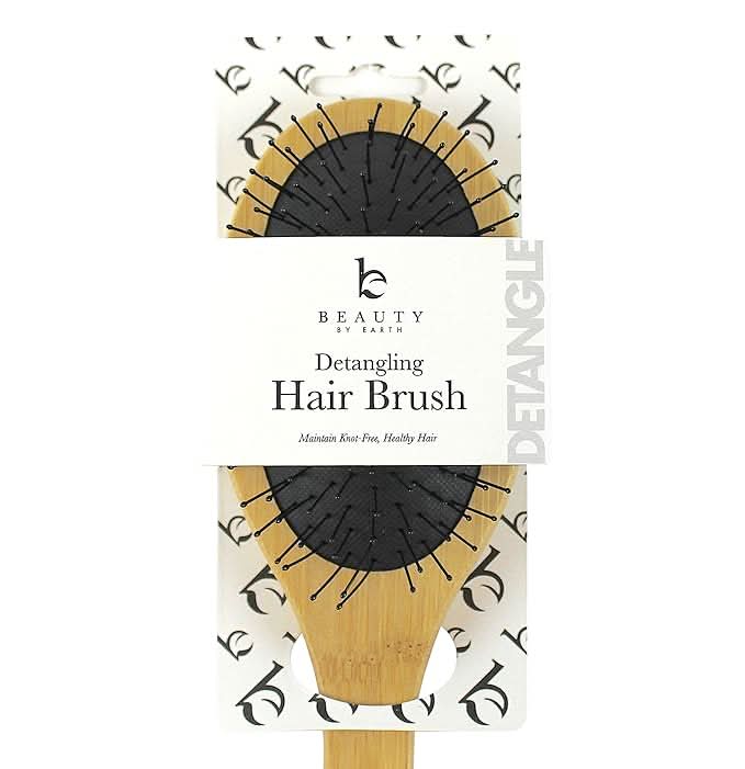 Detangling hair brush packaging with 'Beauty by Earth' branding on a white background