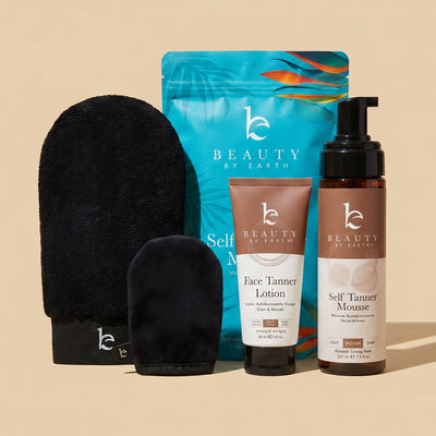 Beauty by Earth self tanning mousse and face lotion fair to medium bundle with application kit black body and face mitt, and exfoliation glove on a beige background.