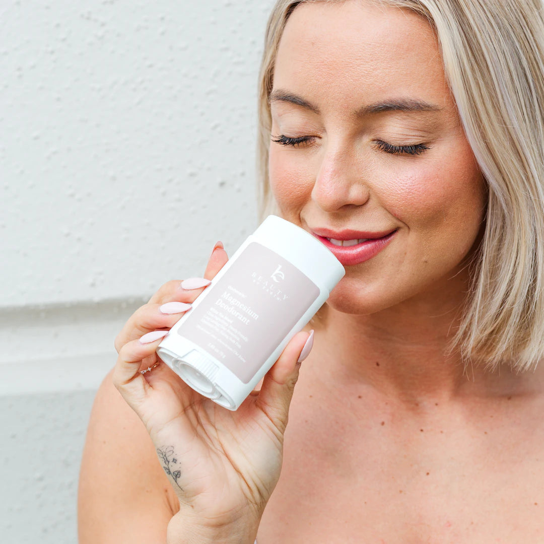 Woman holding deodorant and enjoying the fresh scent