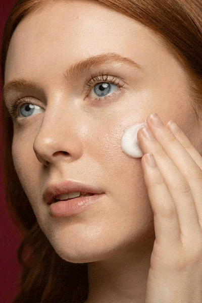 woman applying facial moisturizer