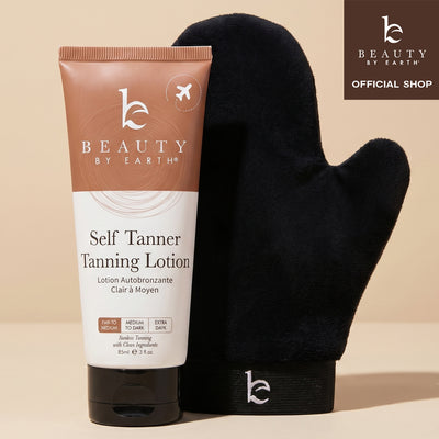 Tube of 'Beauty by Earth' self Tanner tanning lotion with a black mitt on a beige background.